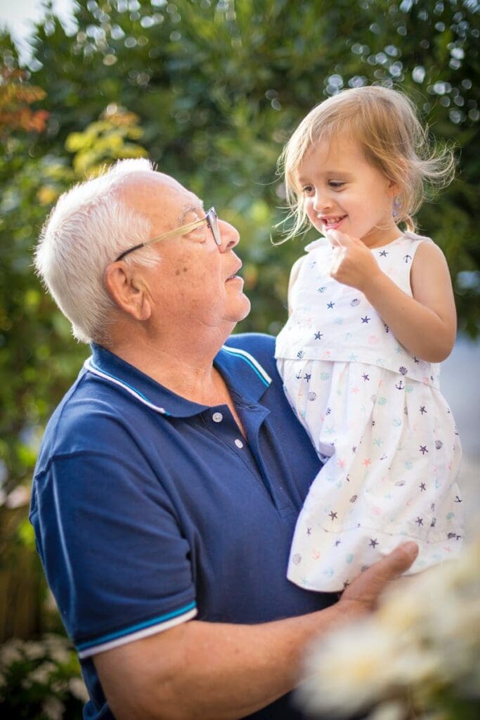 older man holding young girl