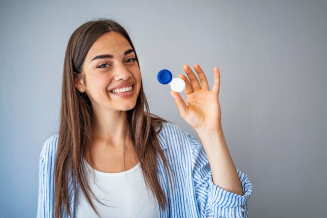 woman with astigmatism holding contacts